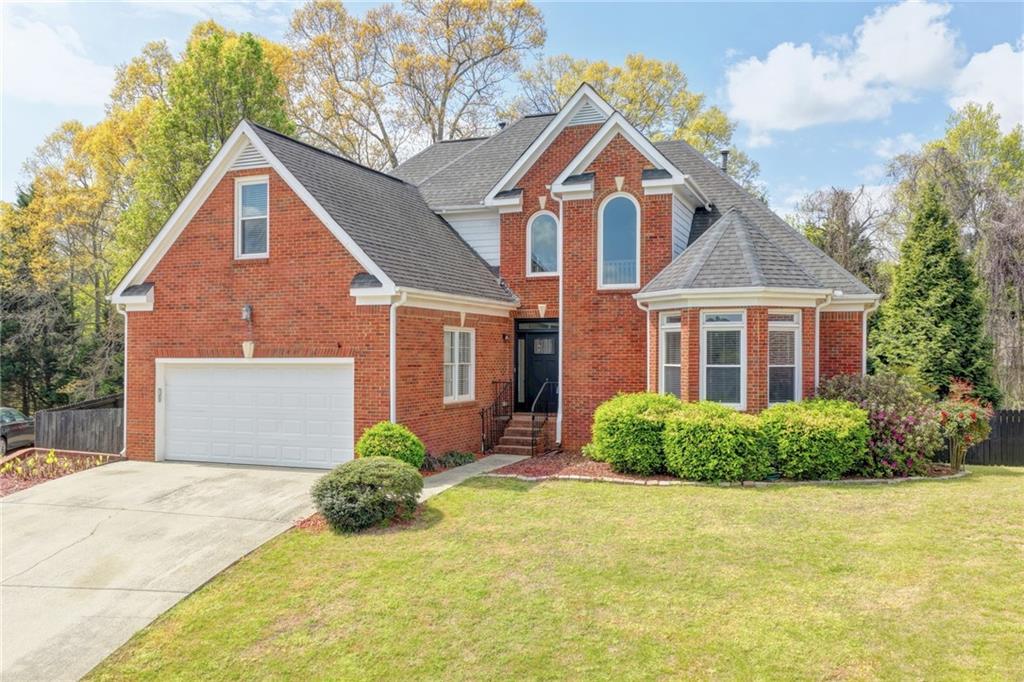 1005 Lewis Ridge Circle Lawrenceville, GA 30045 - Photo 3 of 74 a front view of a house with a yard and garage
