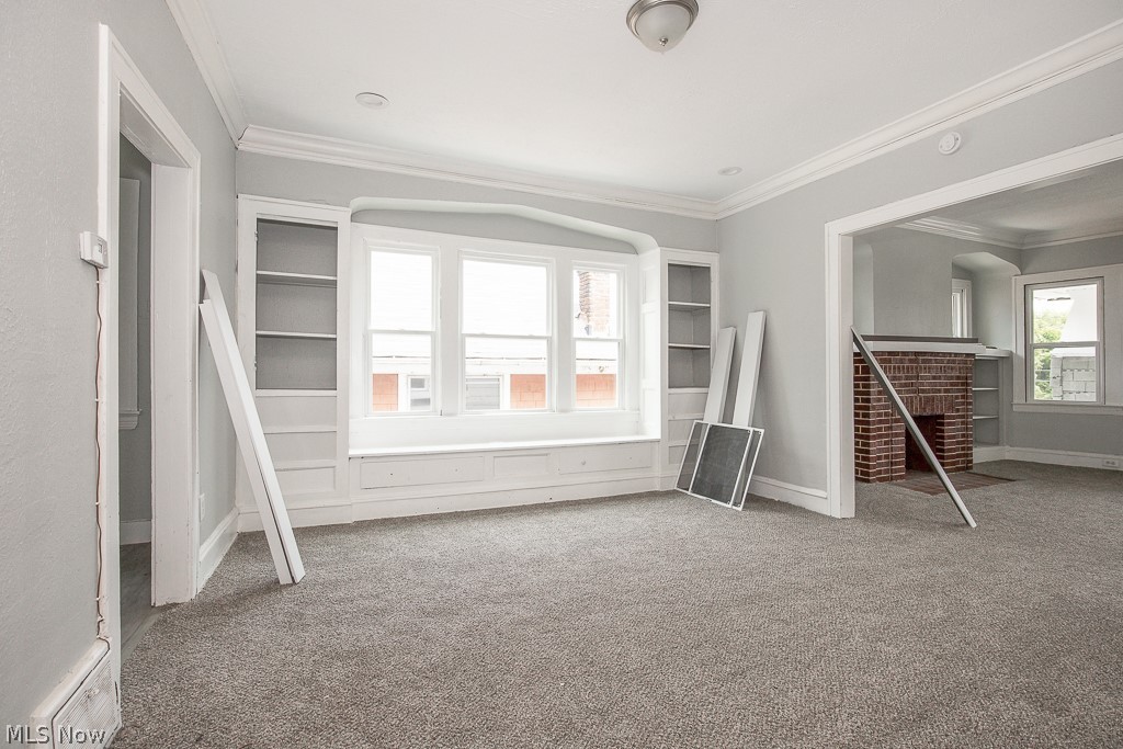1000 Eddy Road Cleveland, OH 44108 - Photo 25 of 38 Carpeted empty room with ornamental molding, plenty of natural light, and a fireplace