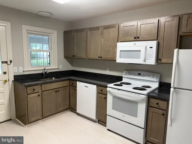 a kitchen with cabinets appliances a sink and a window