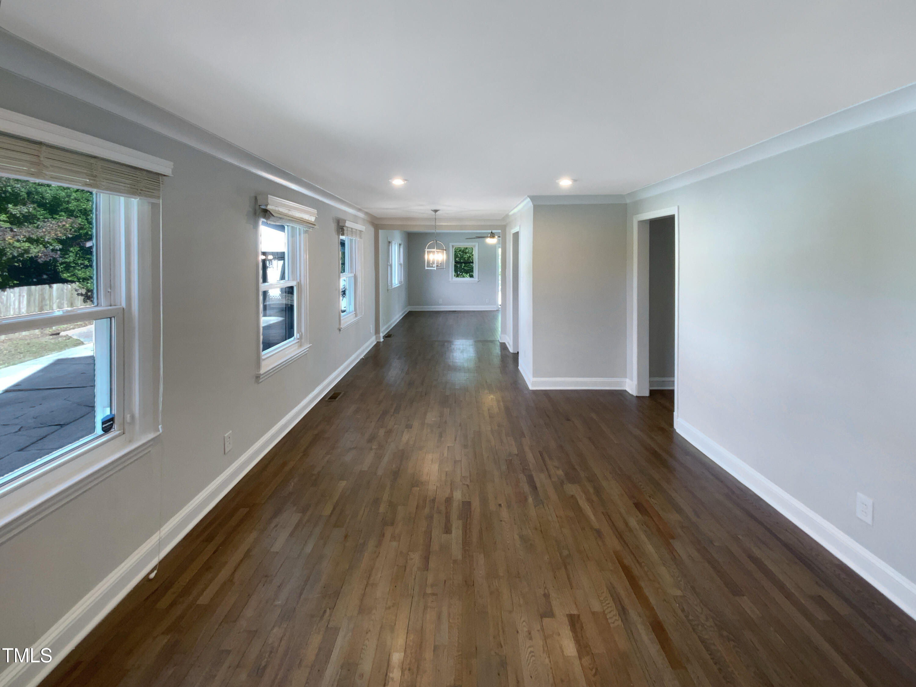 402 North King Charles Road Raleigh, NC 27610 - Photo 9 of 20 a view of an empty room with wooden floor and a window
