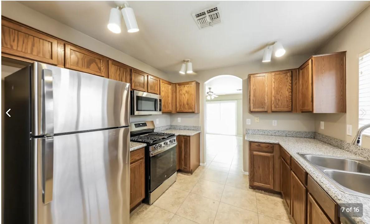 12563 West Charter Oak Road El Mirage, AZ 85335 - Photo 7 of 16 a kitchen with stainless steel appliances granite countertop a refrigerator stove a sink dishwasher and microwave oven