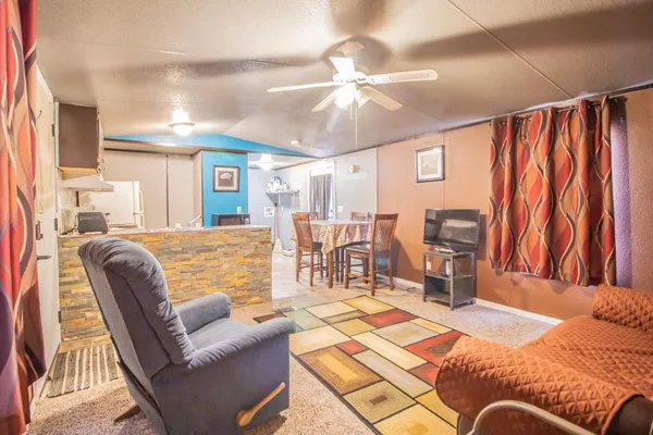 a living room with furniture and a dining table with kitchen view