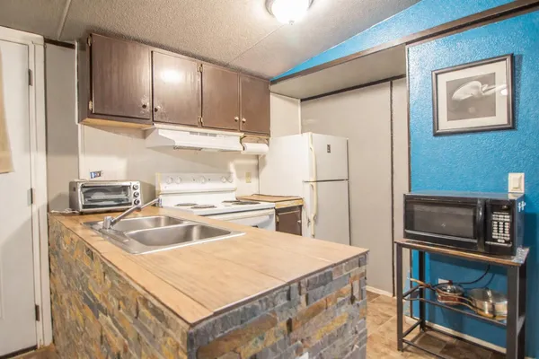 a room with a table chairs and a refrigerator