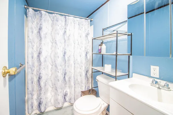 a living room with furniture and a dining table with bookshelf