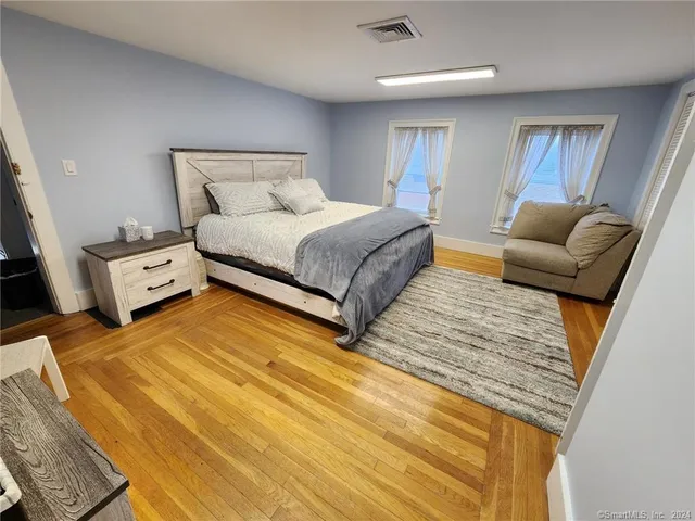 a bedroom with a bed and wooden floor