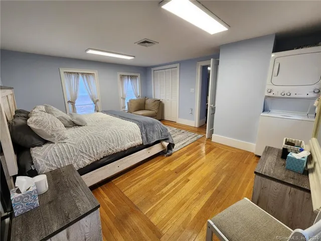 a bedroom with a bed and wooden floor