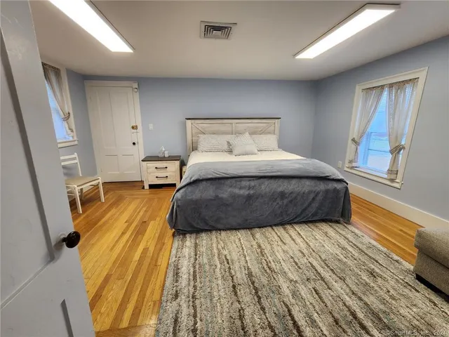 a bedroom with a bed and wooden floor