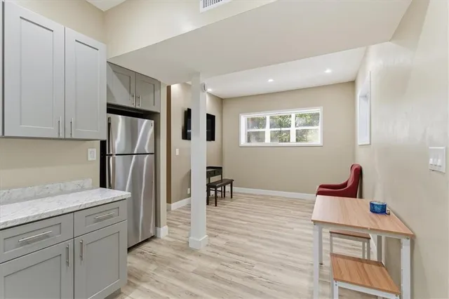 a kitchen with stainless steel appliances granite countertop a refrigerator and a stove top oven