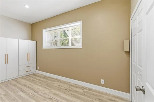 an empty room with wooden floor and window