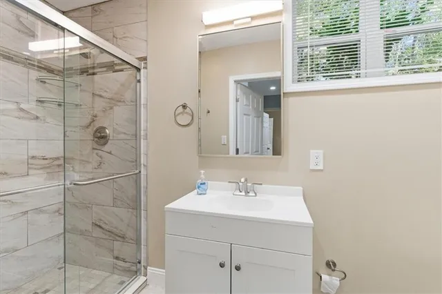 a bathroom with a sink shower and a mirror