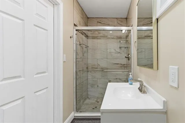 a bathroom with a sink shower and a mirror