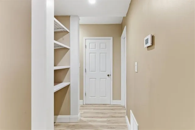 a view of empty room with wooden floor