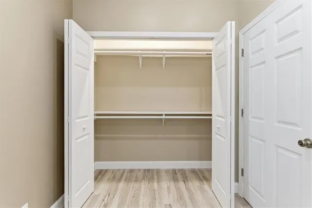 a view of walk in closet with empty racks