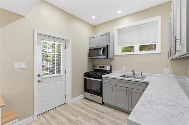 a kitchen with a sink a window and stainless steel appliances