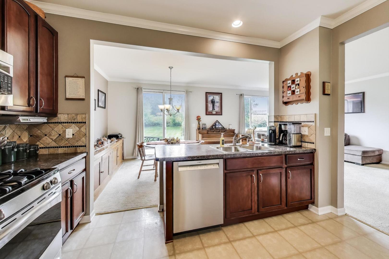 1113 Draper Road McHenry, IL 60050 - Photo 7 of 25 a kitchen with stainless steel appliances granite countertop a stove and a sink