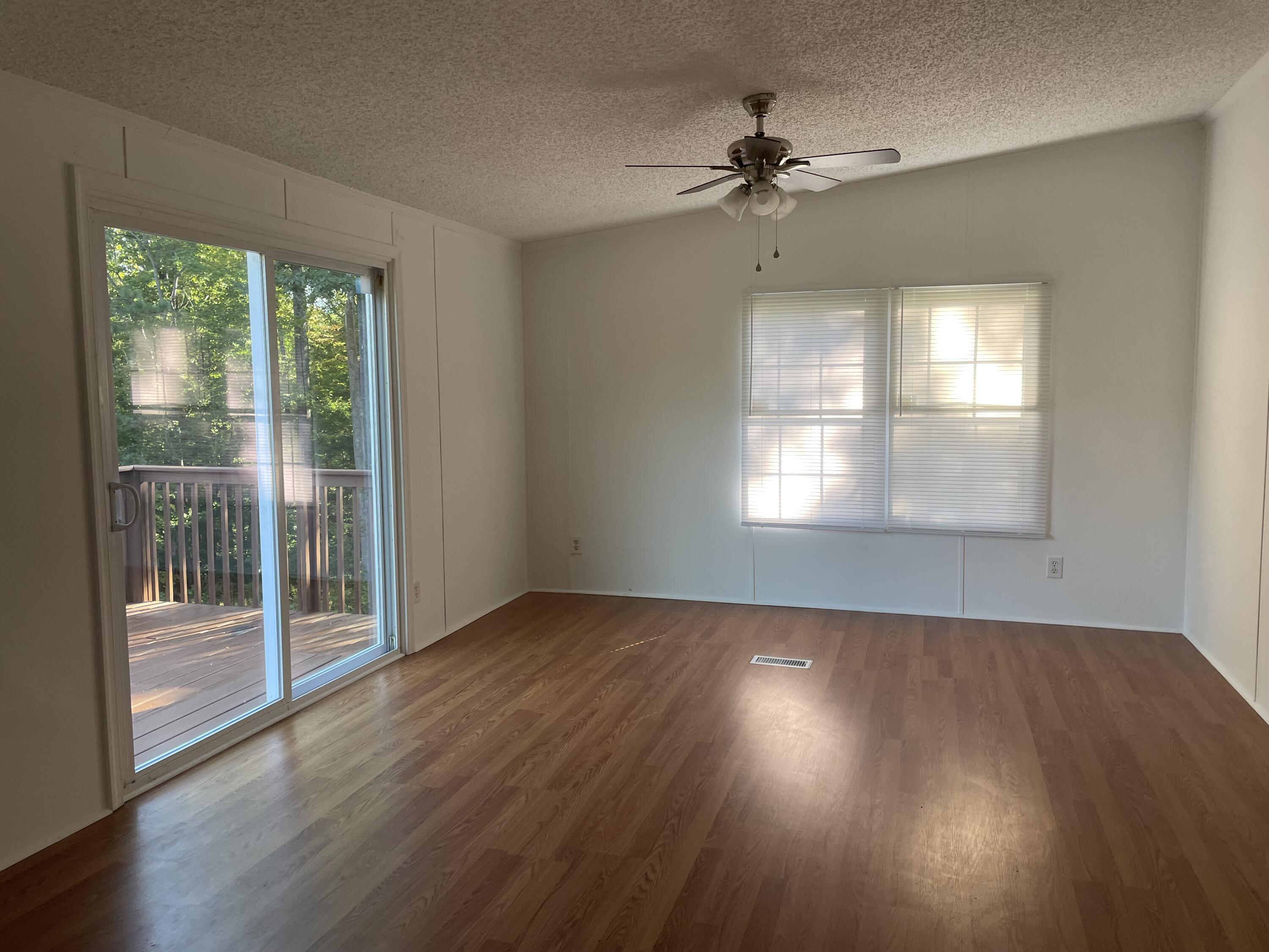 2894 Riverview Road Roanoke, VA 24014 - Photo 8 of 15 an empty room with wooden floor fan and windows