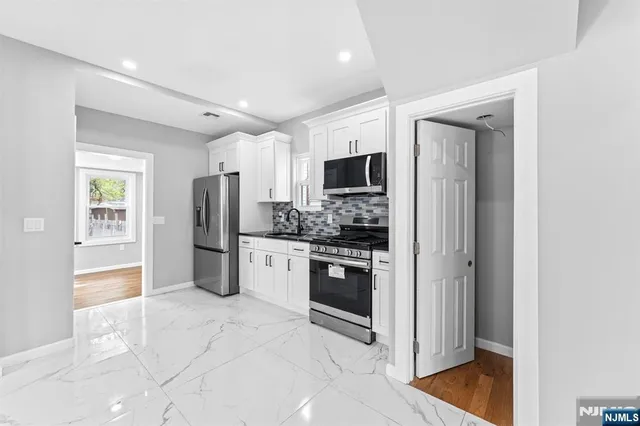 a kitchen with stainless steel appliances granite countertop a refrigerator and a sink