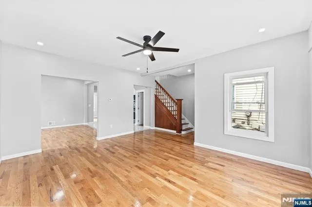 a view of a livingroom with a ceiling fan and wooden floor