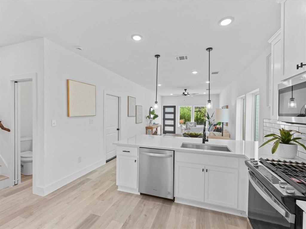 1448 Dewalt Street Houston, TX 77088 - Photo 18 of 24 a kitchen with white cabinets and appliances