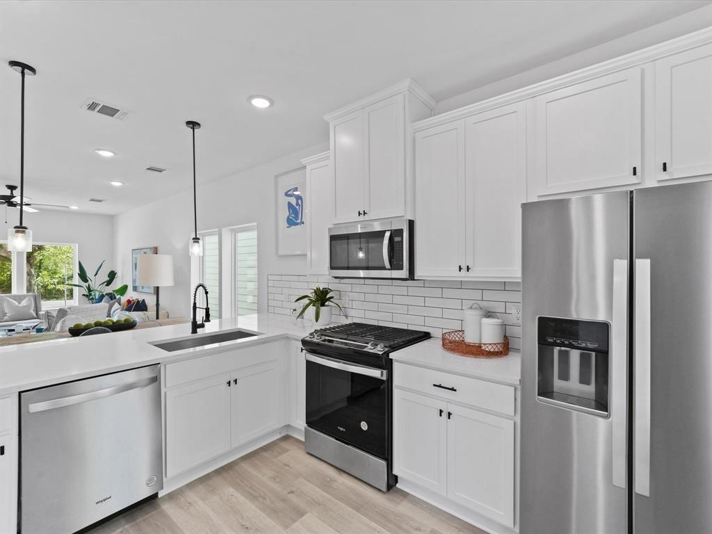 1448 Dewalt Street Houston, TX 77088 - Photo 19 of 24 a kitchen with white cabinets and stainless steel appliances