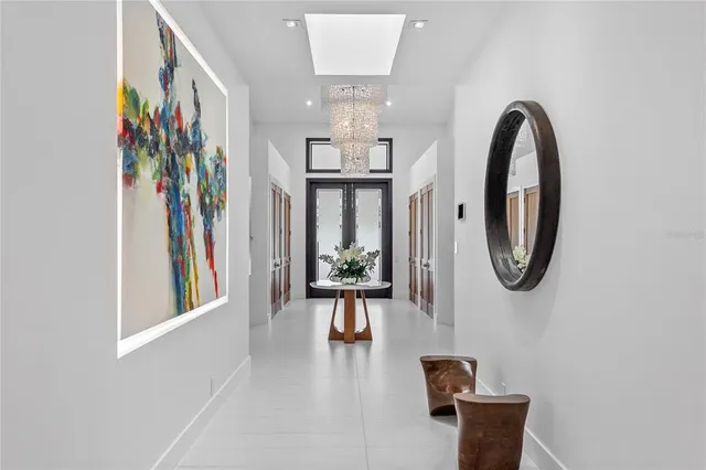 a view of a hallway with wooden floor and a chandelier