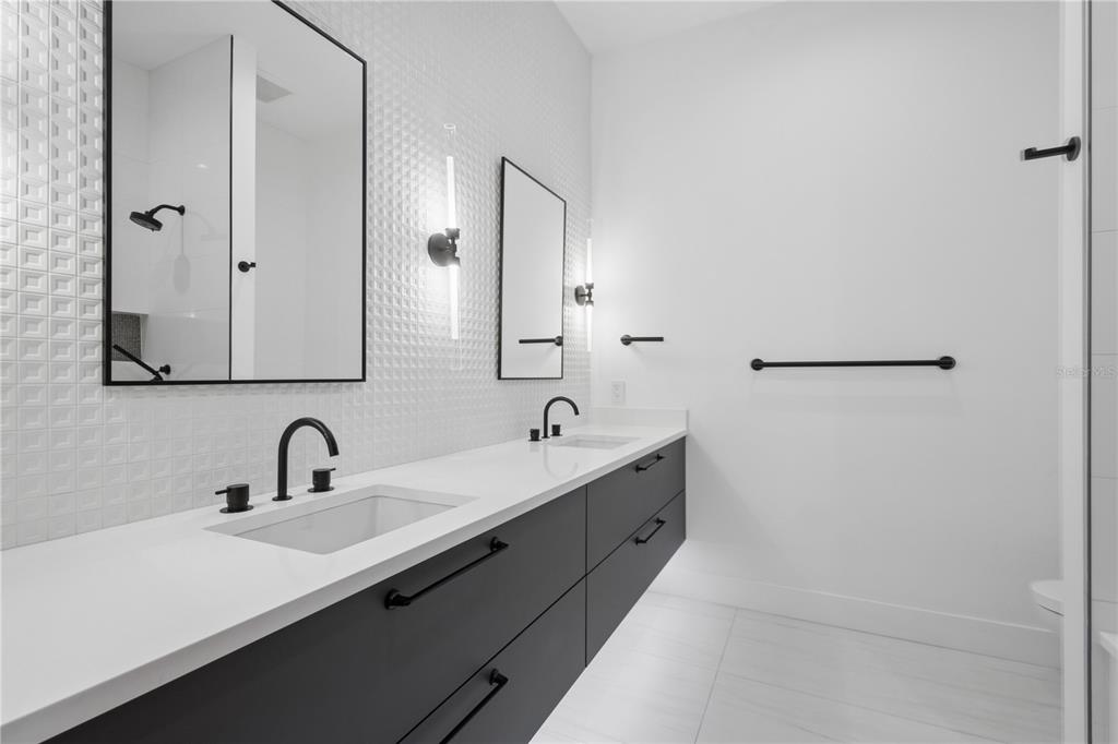 1808 Flower Drive Sarasota, FL 34239 - Photo 32 of 56 a bathroom with a double vanity sink and mirror