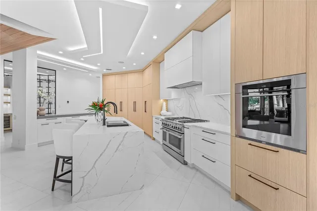 a kitchen with stainless steel appliances kitchen island granite countertop a stove a sink and a refrigerator
