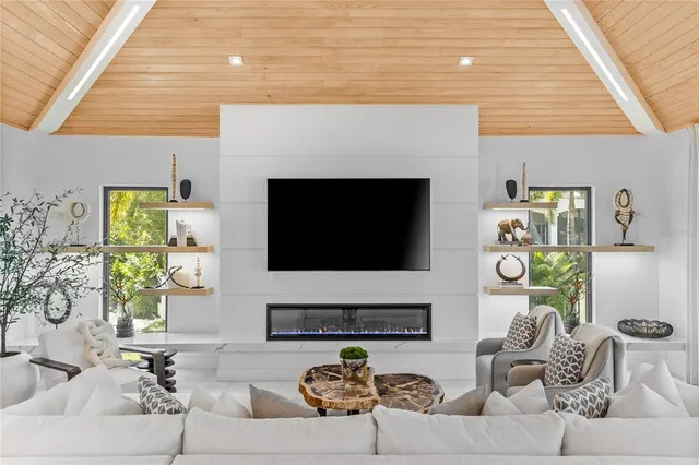 a living room with furniture a fireplace and a flat screen tv