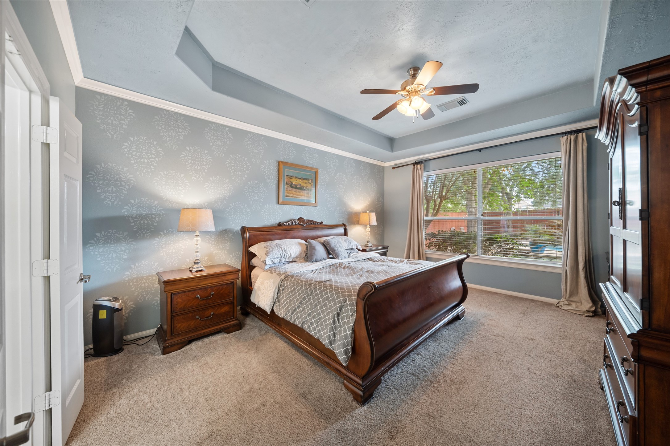 6407 Ashley Manor Drive Spring, TX 77389 - Photo 17 of 41 a spacious bedroom with a bed and a chandelier