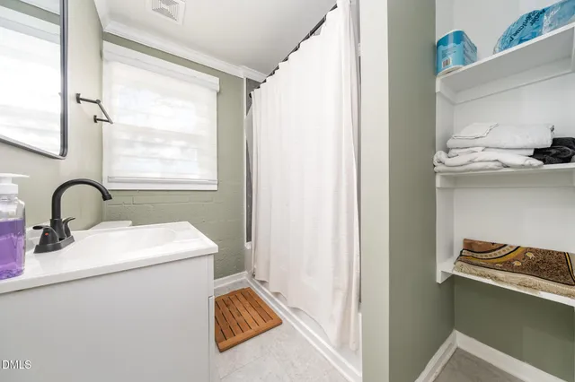 a view of bathroom with a sink and mirror