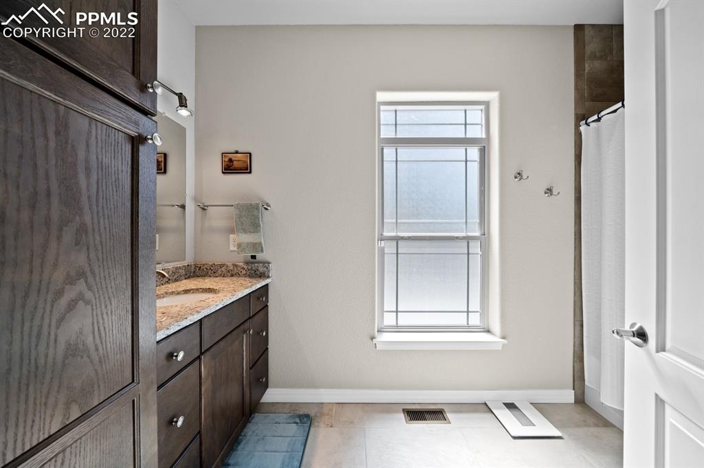 20765 Warriors Path Drive Peyton, CO 80831 - Photo 16 of 50 a bathroom with a granite countertop sink and a window
