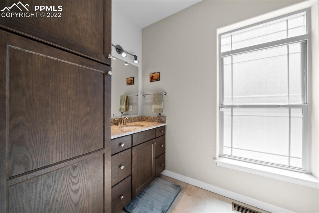 20765 Warriors Path Drive Peyton, CO 80831 - Photo 17 of 50 a bathroom with a granite countertop sink mirror and a shower