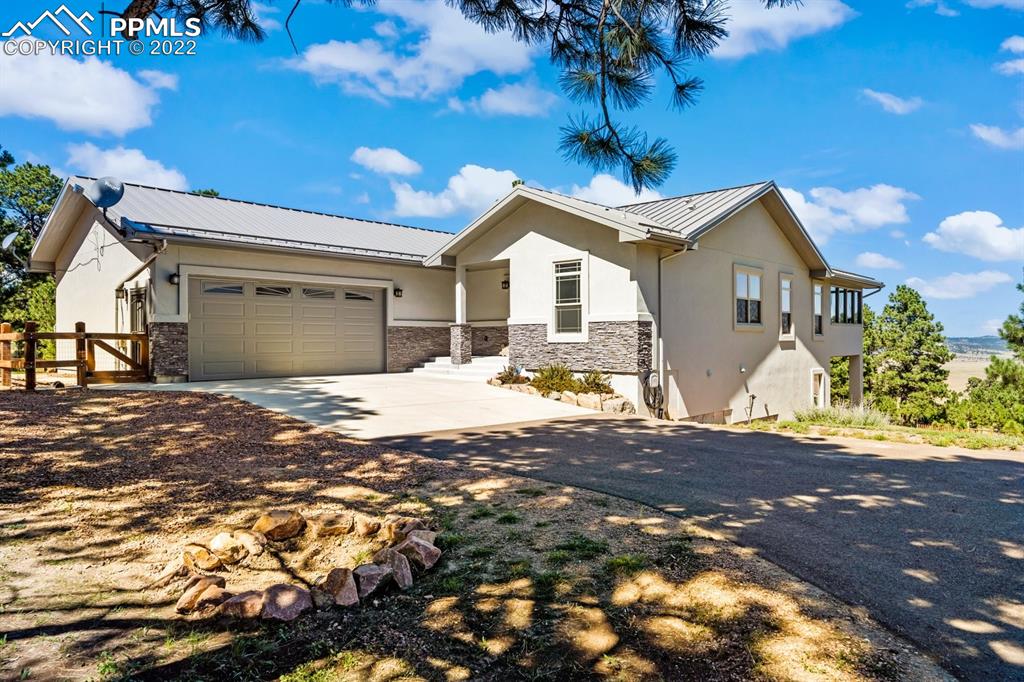 20765 Warriors Path Drive Peyton, CO 80831 - Photo 2 of 50 a front view of a house with a yard and potted plants