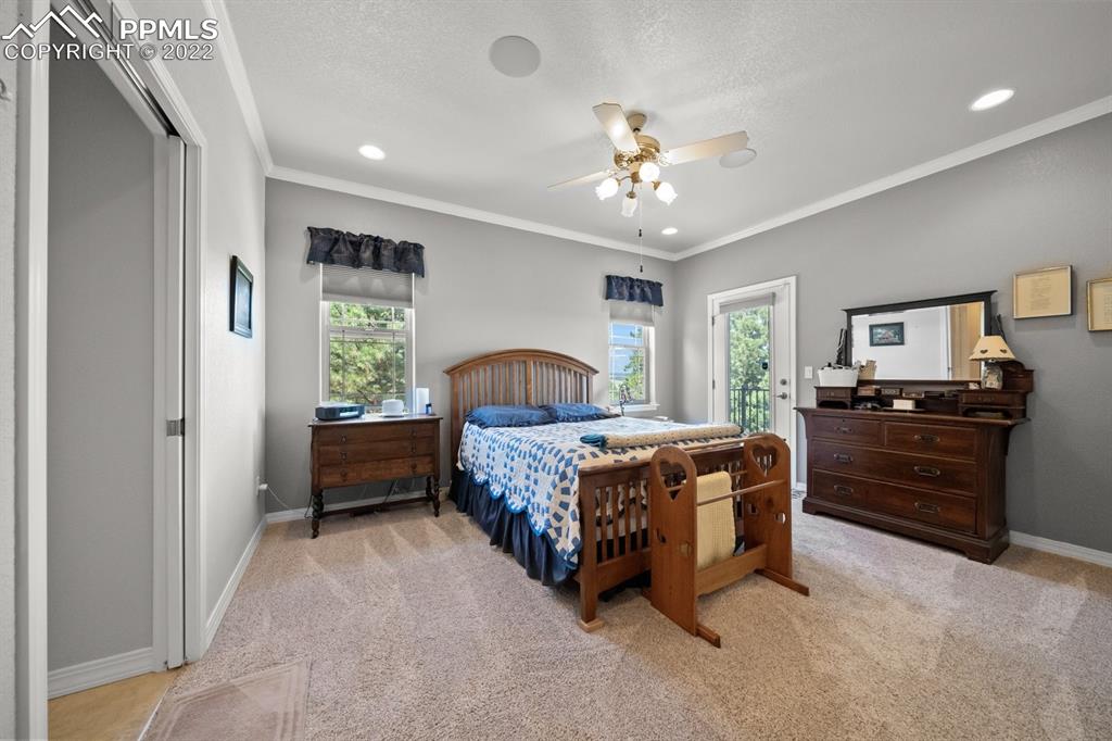 20765 Warriors Path Drive Peyton, CO 80831 - Photo 25 of 50 a bedroom with a bed and a chandelier