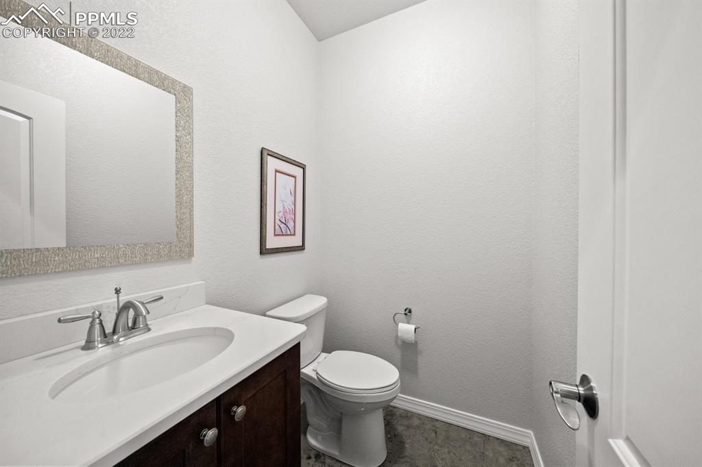 20765 Warriors Path Drive Peyton, CO 80831 - Photo 41 of 50 a bathroom with a sink vanity mirror and toilet