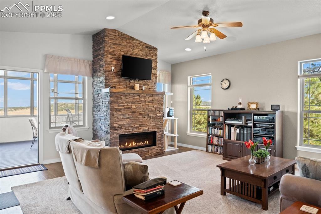 20765 Warriors Path Drive Peyton, CO 80831 - Photo 43 of 50 a living room with furniture a fireplace and a flat screen tv