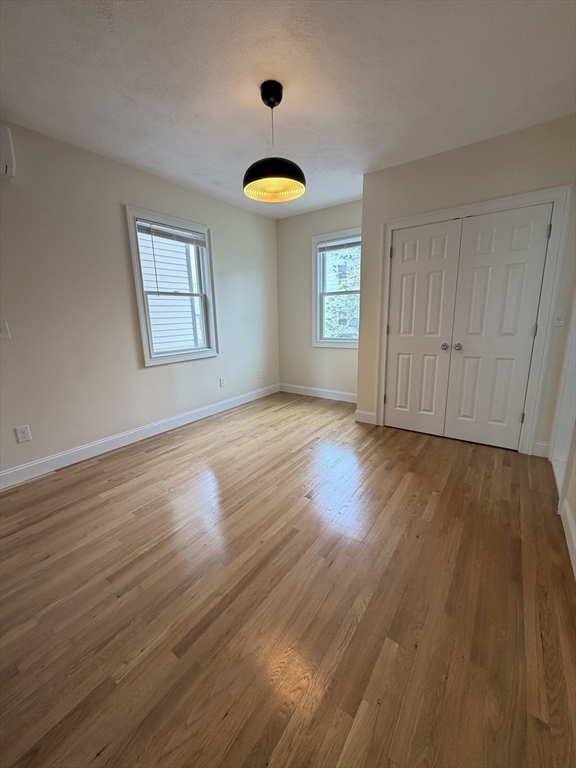 26 Brooks Street, Unit 2 Boston, MA 02128 - Photo 7 of 12 an empty room with wooden floor and windows