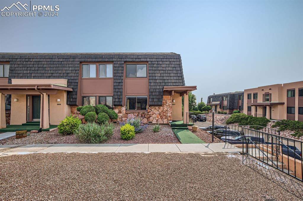 a front view of a house with garden and plants
