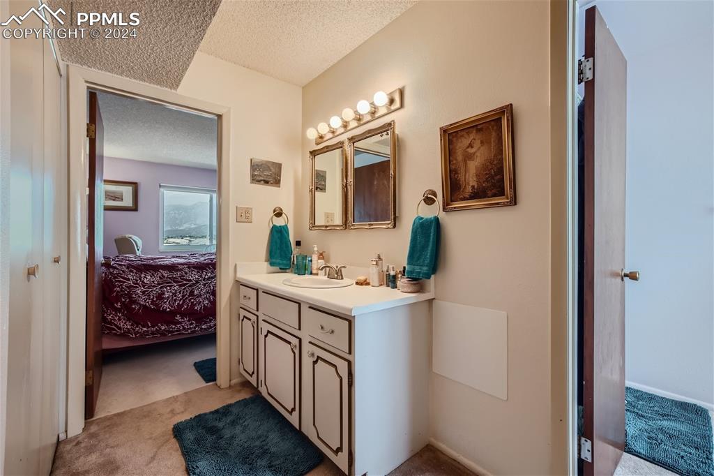 2913 Mesa Road, Unit A Colorado Springs, CO 80904 - Photo 9 of 15 a bathroom with a sink a mirror and a toilet