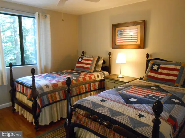 a bedroom with two beds and wooden floor
