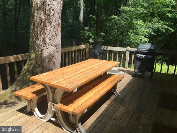 a view of a patio with table and chairs with wooden floor and fence