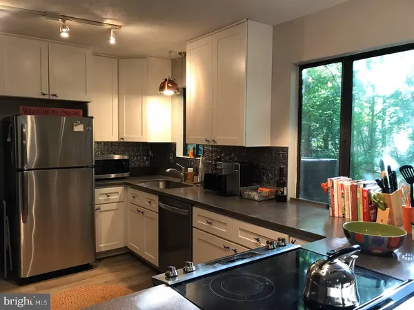a kitchen with stainless steel appliances granite countertop a refrigerator stove and sink