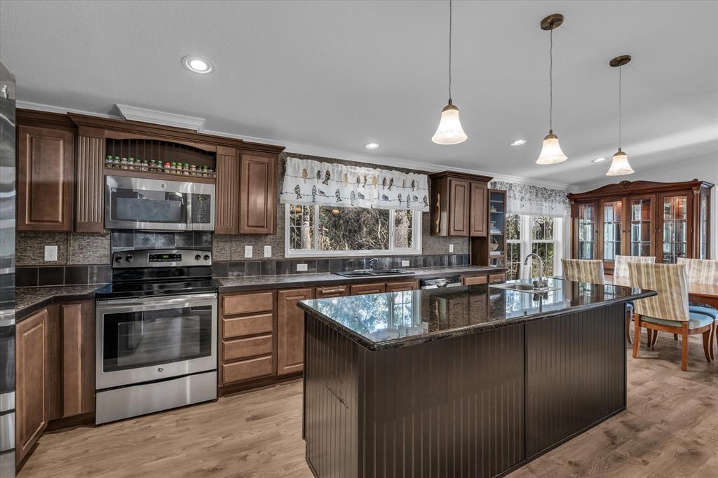 1745 Meixner Road Waco, TX 76705 - Photo 17 of 40 a kitchen with stainless steel appliances granite countertop a sink a stove and a wooden floors