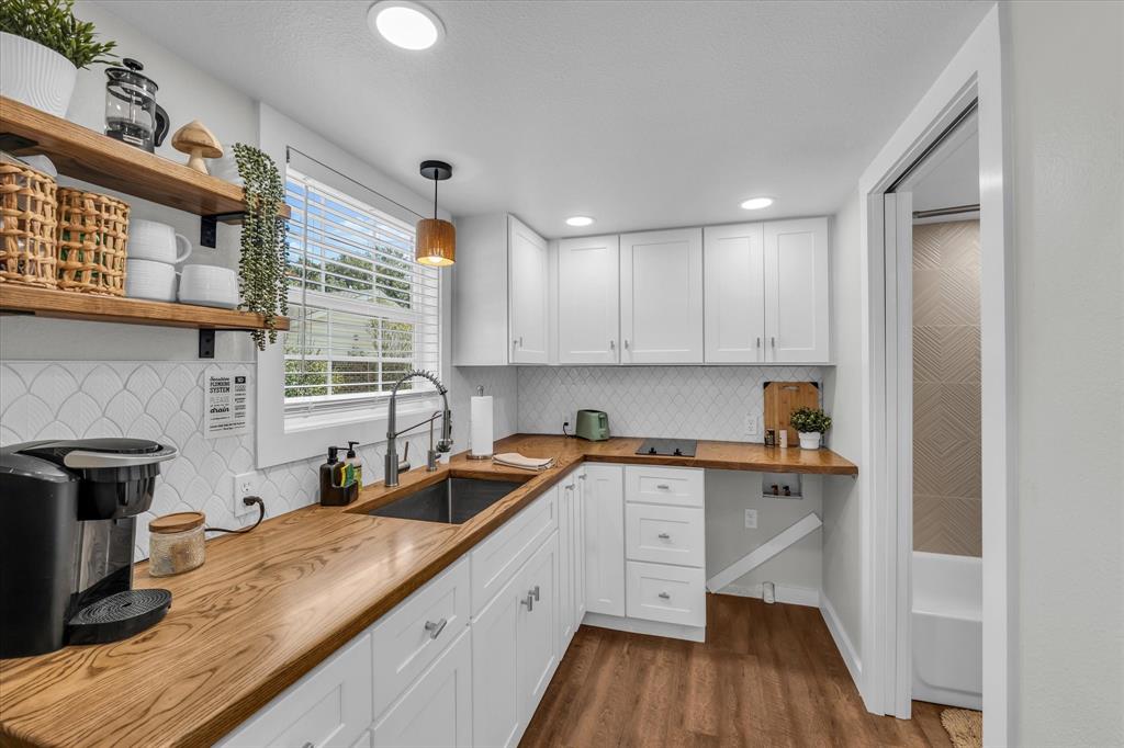 1745 Meixner Road Waco, TX 76705 - Photo 23 of 40 a kitchen with a sink a wooden floor and cabinets