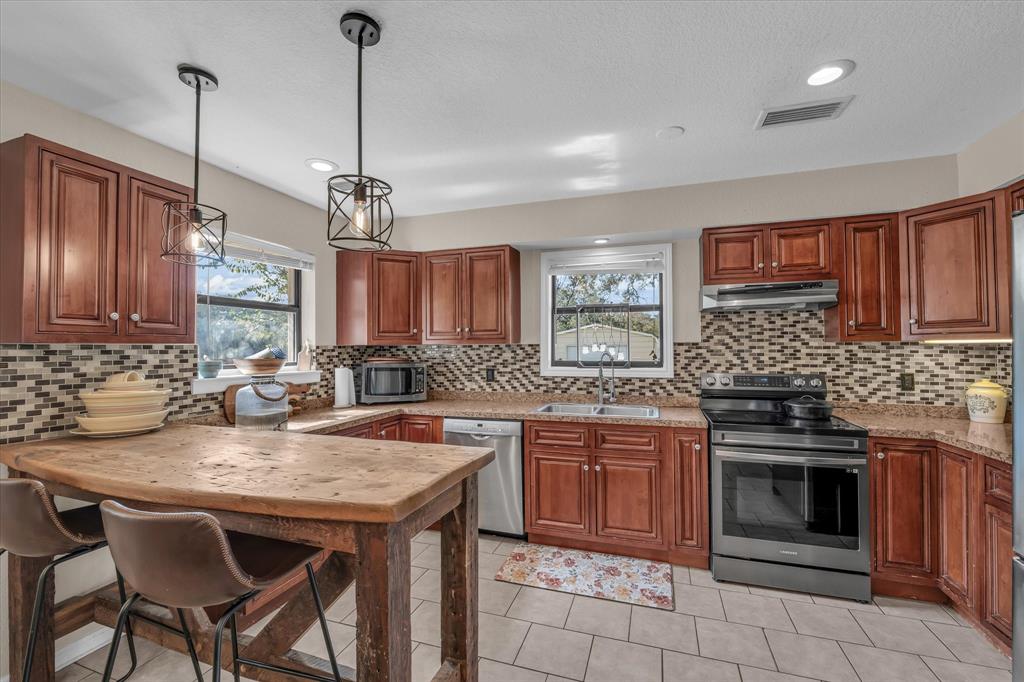1745 Meixner Road Waco, TX 76705 - Photo 10 of 40 a kitchen with stainless steel appliances granite countertop stove top oven table and chairs