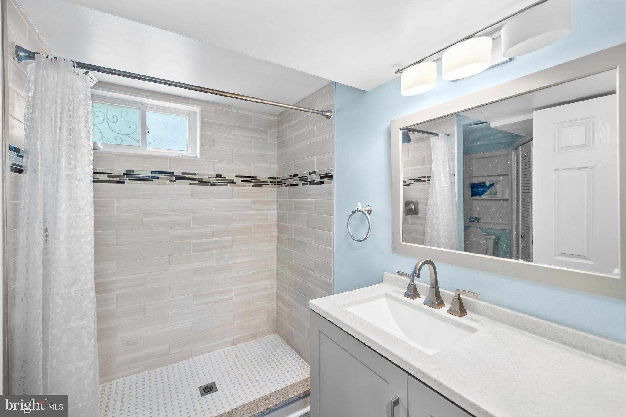 7402 Dunston Street Springfield, VA 22151 - Photo 32 of 37 a bathroom with a granite countertop sink a mirror and shower