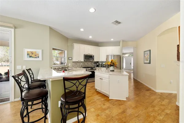 a kitchen with a dining table chairs and refrigerator