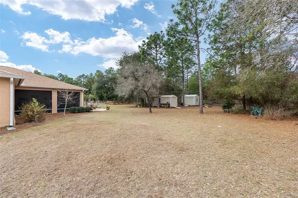 a view of a house with backyard and trees