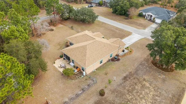 an aerial view of a house with a yard and greenery