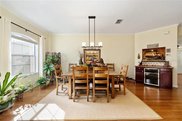 a dining room with furniture potted plants and wooden floor